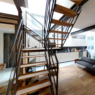 Aménagement d'un grand escalier sans contremarche industriel en U avec des marches en bois.