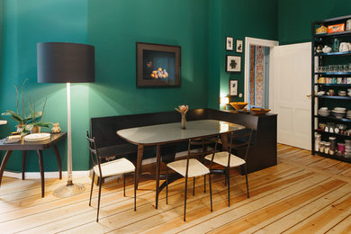Immagine di una sala da pranzo aperta verso la cucina classica di medie dimensioni con pareti verdi, parquet chiaro e nessun camino