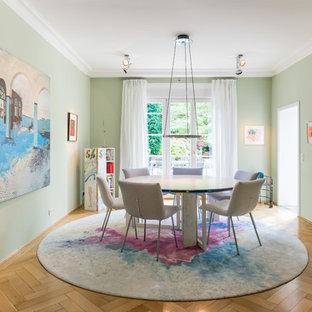 Geschlossenes Eklektisches Esszimmer mit grüner Wandfarbe, braunem Holzboden und beigem Boden in Köln