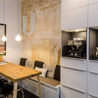 Ispirazione per una piccola sala da pranzo aperta verso la cucina industriale con pareti bianche, nessun camino e pavimento nero