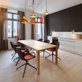 Große Moderne Wohnküche ohne Kamin mit hellem Holzboden, weißer Wandfarbe und beigem Boden in Berlin