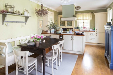 Idée de décoration pour une salle à manger ouverte sur la cuisine champêtre de taille moyenne avec un sol en bois brun et un mur gris.