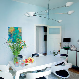 Esempio di una sala da pranzo boho chic con pareti blu e pavimento in legno massello medio