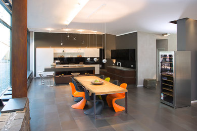Идея дизайна: большая кухня-столовая в современном стиле с разноцветными стенами и серым полом