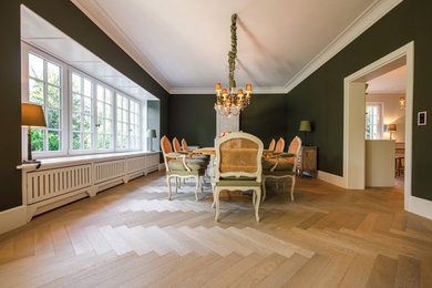 Landhaus Esszimmer mit grüner Wandfarbe, braunem Holzboden und beigem Boden in Sonstige