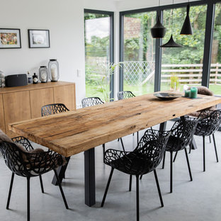Geschlossenes, Mittelgroßes Modernes Esszimmer ohne Kamin mit Betonboden, weißer Wandfarbe und grauem Boden in München