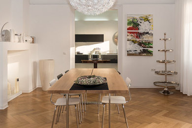 Modernes Esszimmer mit weißer Wandfarbe und braunem Holzboden in Sonstige