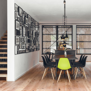 Modernes Esszimmer mit weißer Wandfarbe, braunem Holzboden und braunem Boden in Nürnberg