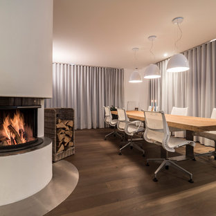 Geschlossenes, Großes Modernes Esszimmer mit weißer Wandfarbe, braunem Holzboden, Eckkamin, braunem Boden und verputzter Kaminumrandung in Stuttgart