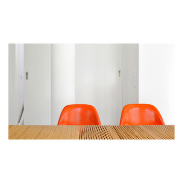 Esszimmertisch aus Holz mit knalligen Stühlen