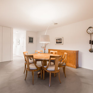 Offenes, Großes Modernes Esszimmer ohne Kamin mit weißer Wandfarbe, Betonboden und grauem Boden in Köln