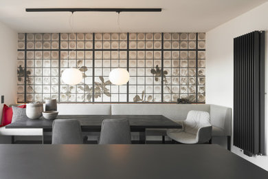 Cette image montre une salle à manger ouverte sur la cuisine design de taille moyenne avec un mur blanc, parquet foncé, aucune cheminée et un sol marron.