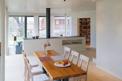 Cette photo montre une grande salle à manger tendance avec un mur gris, parquet peint, une cheminée standard et un manteau de cheminée en métal.