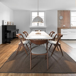 Offenes, Mittelgroßes Industrial Esszimmer ohne Kamin mit weißer Wandfarbe, braunem Holzboden und braunem Boden in Hamburg