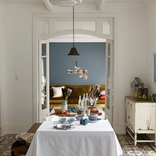 Exemple d'une salle à manger romantique avec un mur bleu et un sol en carrelage de porcelaine.