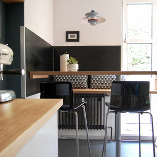 Kleine Moderne Wohnküche ohne Kamin mit weißer Wandfarbe und grauem Boden in Berlin