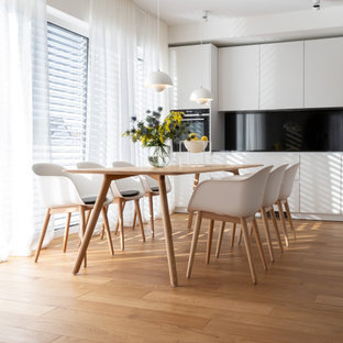 Mittelgroße Moderne Wohnküche mit weißer Wandfarbe, braunem Holzboden und beigem Boden in Köln