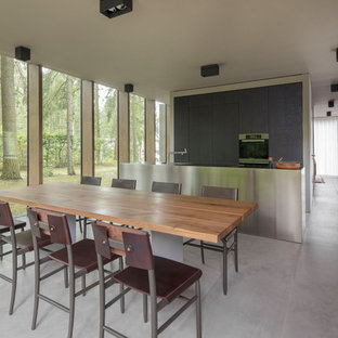Große Moderne Wohnküche ohne Kamin mit weißer Wandfarbe, Betonboden und grauem Boden in Berlin