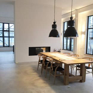 Inspiration för stora moderna matplatser med öppen planlösning, med vita väggar, en bred öppen spis och betonggolv