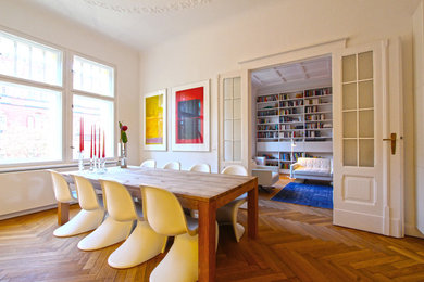 Ejemplo de comedor escandinavo de tamaño medio cerrado sin chimenea con paredes blancas y suelo de madera en tonos medios