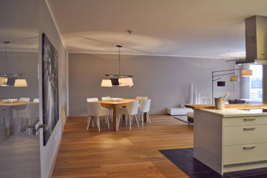 Offenes, Geräumiges Modernes Esszimmer mit grauer Wandfarbe, braunem Holzboden, Tapetendecke und Tapetenwänden in Sonstige