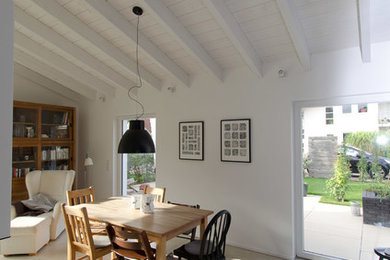 Foto de comedor campestre de tamaño medio abierto sin chimenea con suelo gris, paredes blancas y suelo de cemento