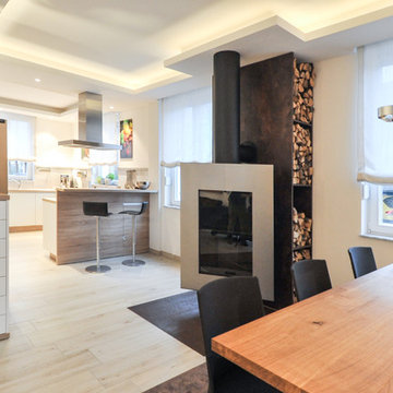 offene Wohnküche und Tisch im Wohnbereich mit schwenkbaren Kamin