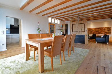 Example of a large cottage medium tone wood floor great room design in Frankfurt with white walls