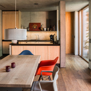 Moderne Wohnküche mit grauer Wandfarbe, dunklem Holzboden und braunem Boden in Sonstige