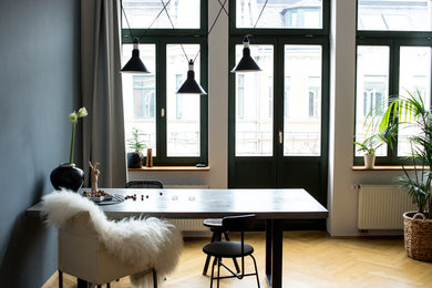 Geschlossenes, Mittelgroßes Skandinavisches Esszimmer mit grauer Wandfarbe und braunem Holzboden in Leipzig