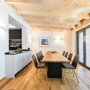 Mittelgroße Moderne Wohnküche mit weißer Wandfarbe, hellem Holzboden und braunem Boden in Leipzig