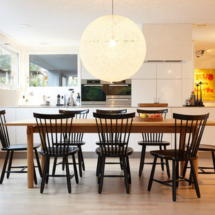 Mittelgroße Moderne Wohnküche ohne Kamin mit weißer Wandfarbe, hellem Holzboden und braunem Boden in Hamburg