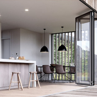 Moderne Wohnküche mit grauer Wandfarbe, hellem Holzboden und beigem Boden in Bremen