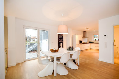 Mittelgroße Moderne Wohnküche mit weißer Wandfarbe und braunem Holzboden in Sonstige