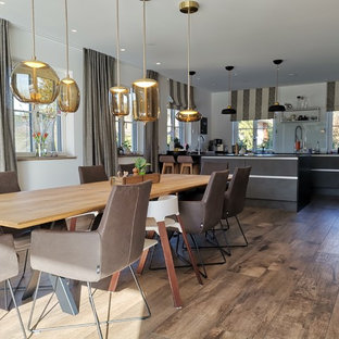 Foto på en stor funkis matplats med öppen planlösning, med vita väggar, klinkergolv i keramik, en bred öppen spis och en spiselkrans i gips