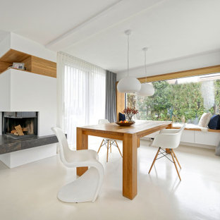 Immagine di una grande sala da pranzo aperta verso il soggiorno design con pareti bianche, pavimento in compensato, camino ad angolo e pavimento beige