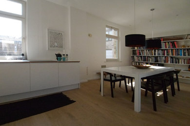 Photo of a large scandinavian kitchen/dining room in Stuttgart with white walls and light hardwood flooring.