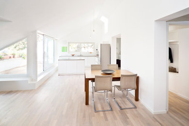 Mittelgroße Moderne Wohnküche mit weißer Wandfarbe, braunem Holzboden und braunem Boden in Berlin