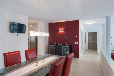 На фото: огромная гостиная-столовая в современном стиле с красными стенами и полом из керамической плитки