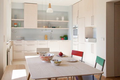 Kleine Skandinavische Wohnküche ohne Kamin mit beiger Wandfarbe, braunem Holzboden und braunem Boden in Berlin