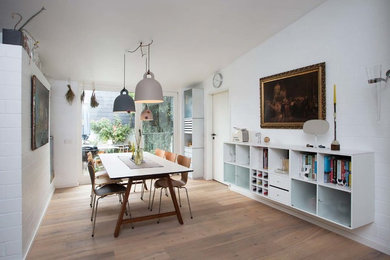 Geschlossenes, Mittelgroßes Modernes Esszimmer ohne Kamin mit weißer Wandfarbe, braunem Holzboden und beigem Boden in Sonstige