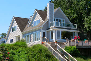 Foto de fachada gris contemporánea de tamaño medio de dos plantas con revestimiento de madera y tejado a dos aguas