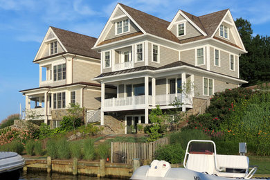 Imagen de fachada gris costera de tamaño medio de tres plantas con revestimiento de madera