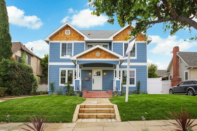 Diseño de fachada de casa azul de estilo americano de tamaño medio de dos plantas con revestimientos combinados, tejado a dos aguas y tejado de teja de madera