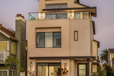 Example of a trendy beige three-story house exterior design in Orange County