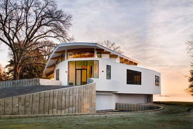 Imagen de fachada de casa blanca minimalista extra grande de tres plantas con revestimiento de estuco, tejado de un solo tendido y tejado de metal