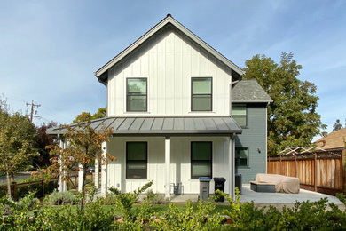 Diseño de fachada de casa bifamiliar multicolor tradicional renovada grande de dos plantas con revestimiento de madera, tejado a cuatro aguas y tejado de teja de madera