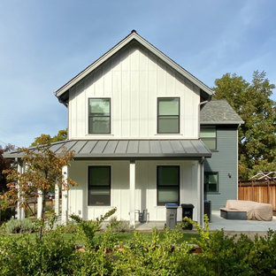 Réalisation d'une grand façade de maison multicolore tradition à un étage avec un toit à quatre pans et un toit en shingle.