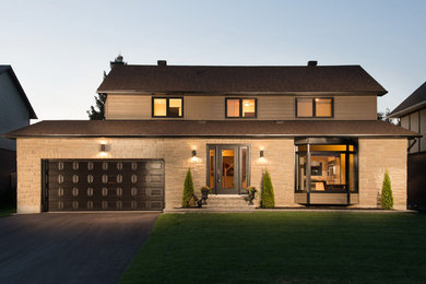 Immagine della facciata di una casa grande marrone classica a due piani con rivestimento con lastre in cemento e tetto a capanna