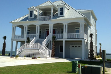 Example of a huge beach style gray three-story vinyl house exterior design in Other